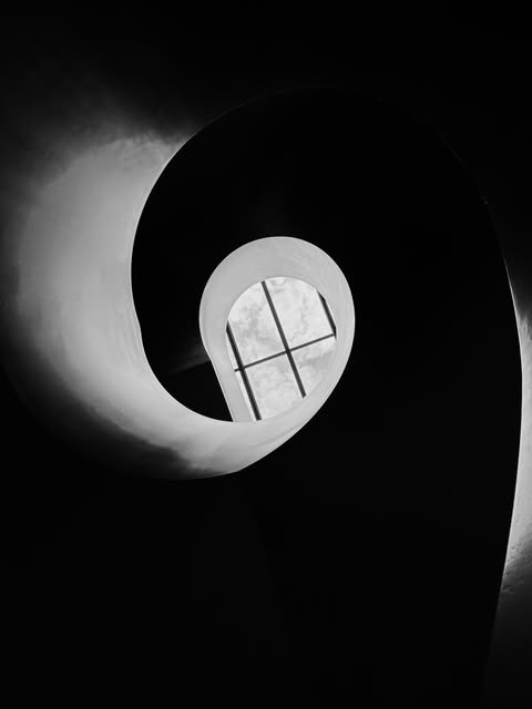 Black-and-white sculptural interior with a circular opening