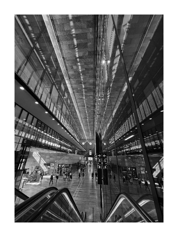 Black-and-white architectural view inside a contemporary railway station, photographed by Ben Taleb